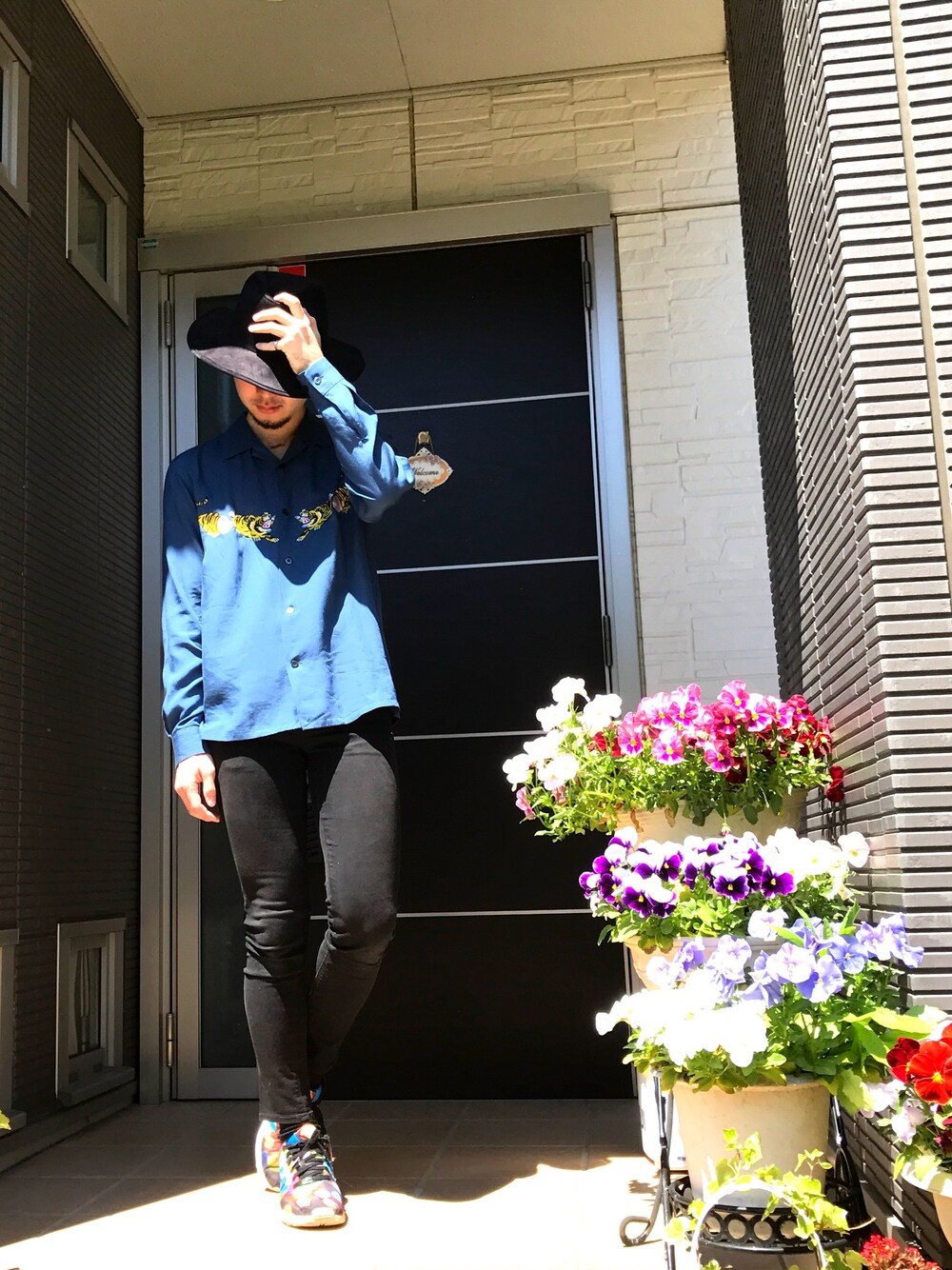 ブルー系のシャツ/ブラウス、ブラック系のデニムパンツ、ブラック系のスニーカーを着用したメンズの春コーディネートの1枚目の写真