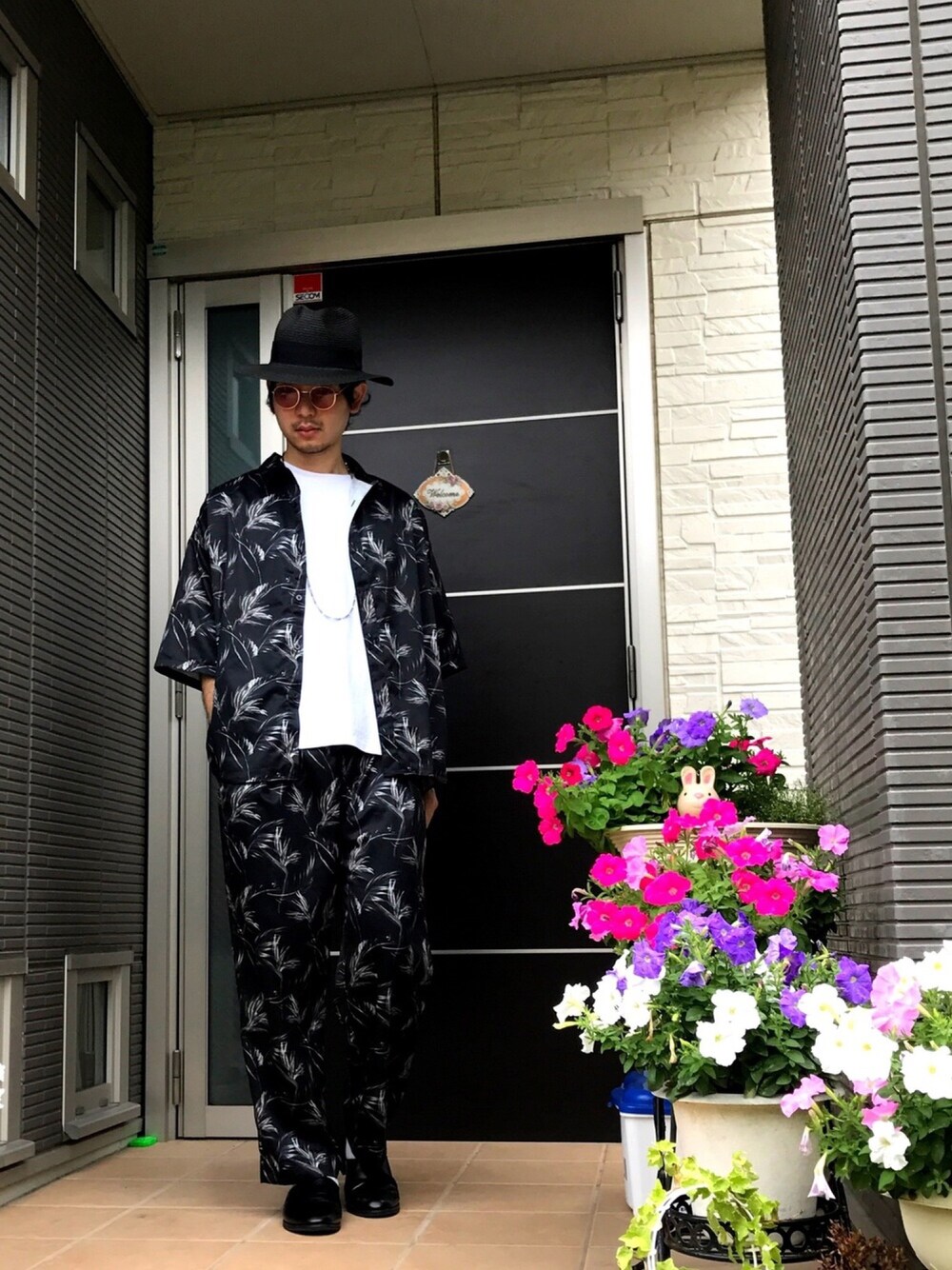 ブラック系のトップス、ブラック系のパンツ、ホワイト系のTシャツ/カットソーを着用したメンズの夏コーディネートの1枚目の写真