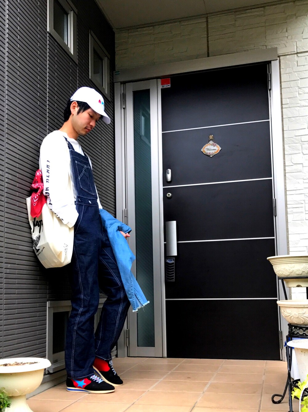 ホワイト系のTシャツ/カットソー、グレー系のデニムパンツ、ブラック系のスニーカーを着用したメンズの秋コーディネートの1枚目の写真