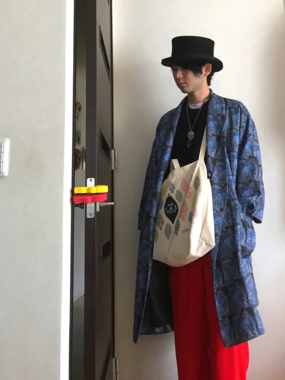 ブラック系のニット/セーター、ブルー系のジャケット/アウター、レッド系のパンツを着用したメンズの春コーディネートの1枚目の写真