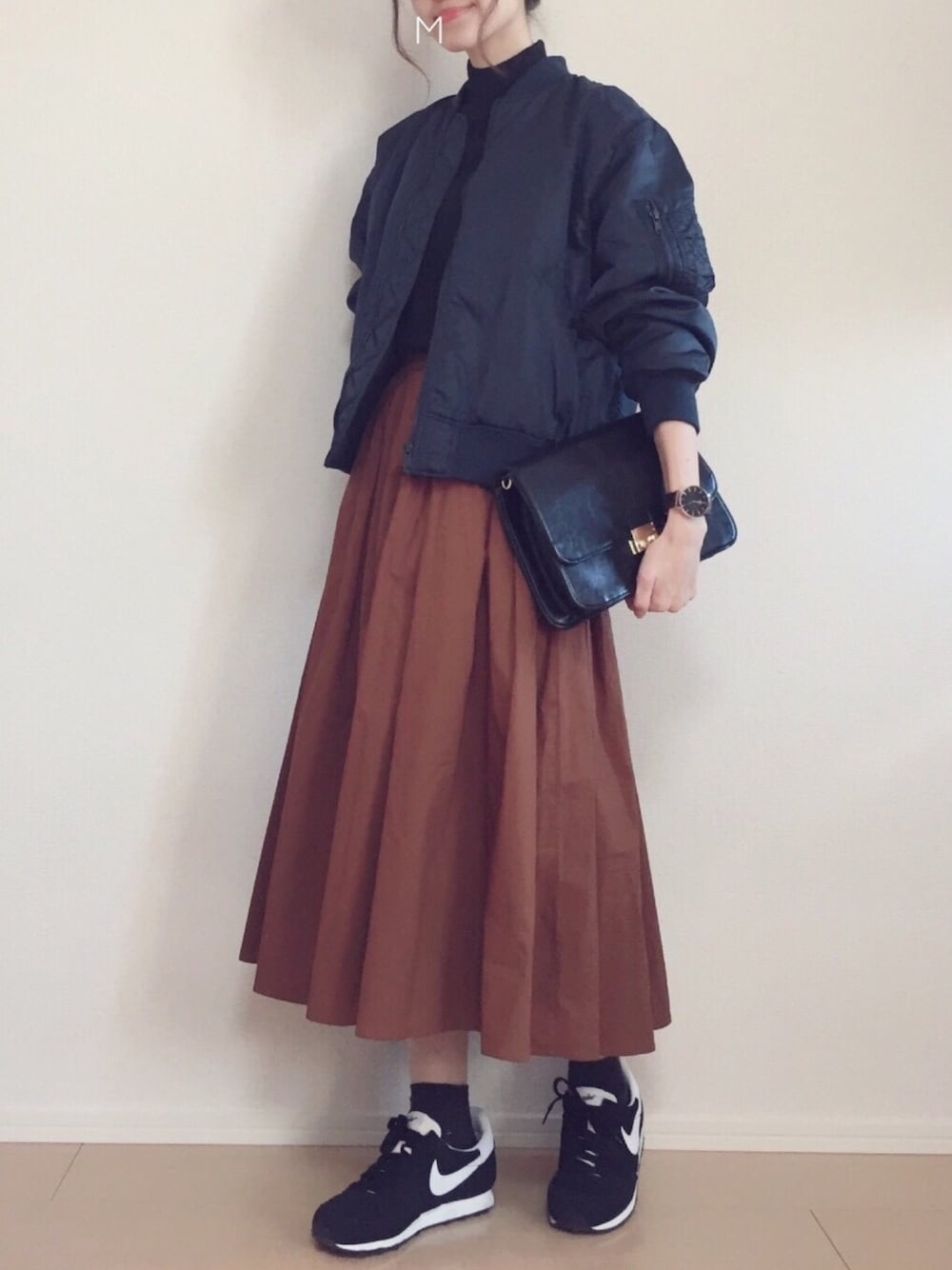 ブルー系のMA-1、イエロー系のスカート、ブラック系のショルダーバッグを着用したレディースの冬コーディネートの1枚目の写真