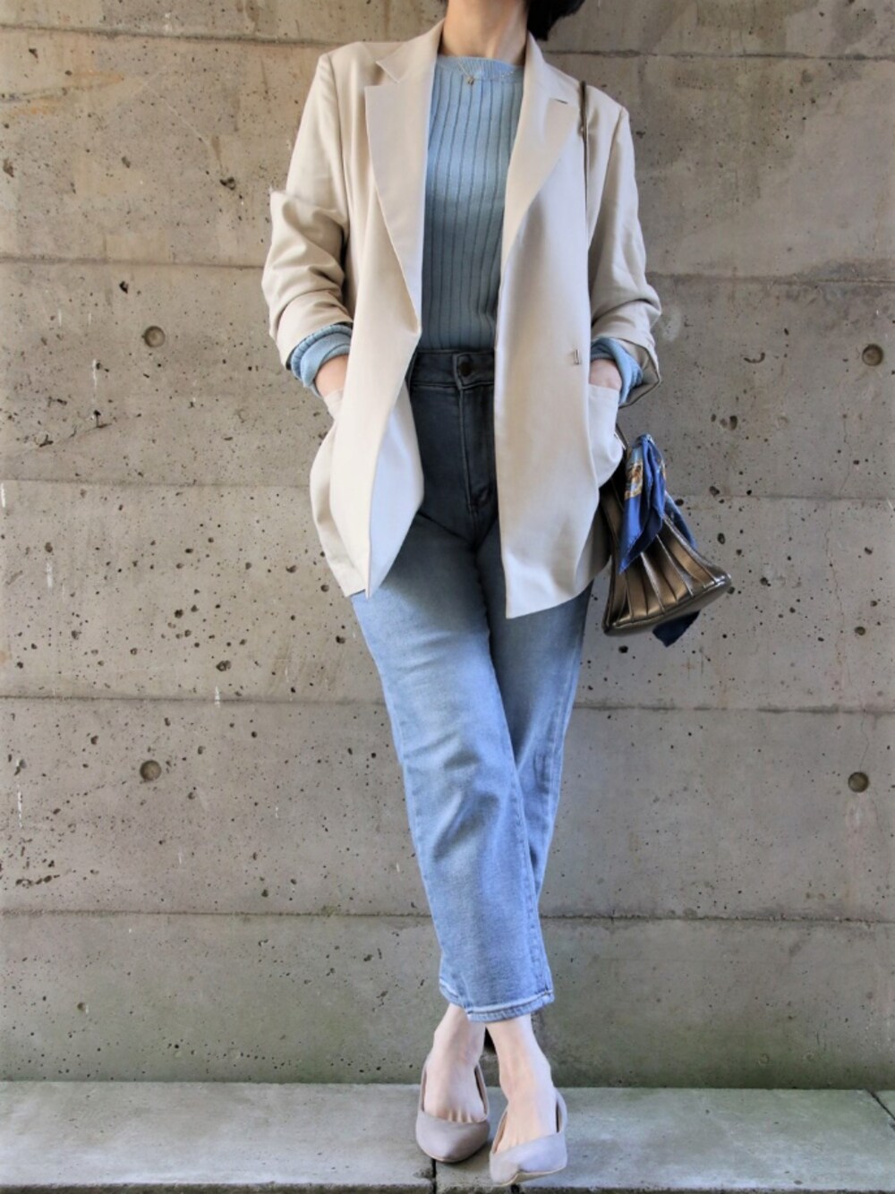 ブルー系のデニムパンツ、ベージュ系のテーラードジャケット、ブルー系のニット/セーターを着用したレディースの冬コーディネートの1枚目の写真