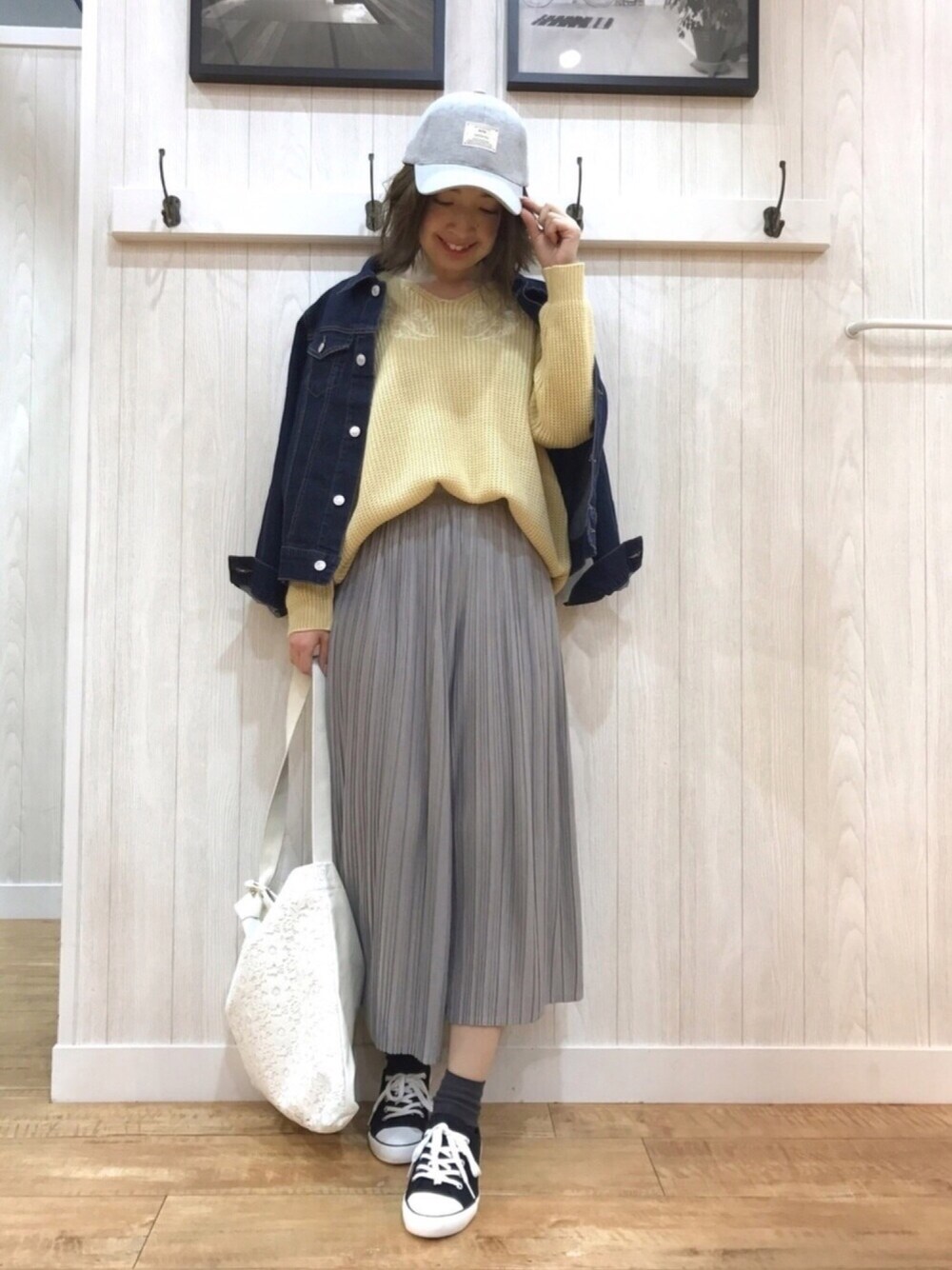 ブルー系のデニムジャケット、イエロー系のニット/セーター、グレー系のその他パンツを着用したレディースの冬コーディネートの1枚目の写真