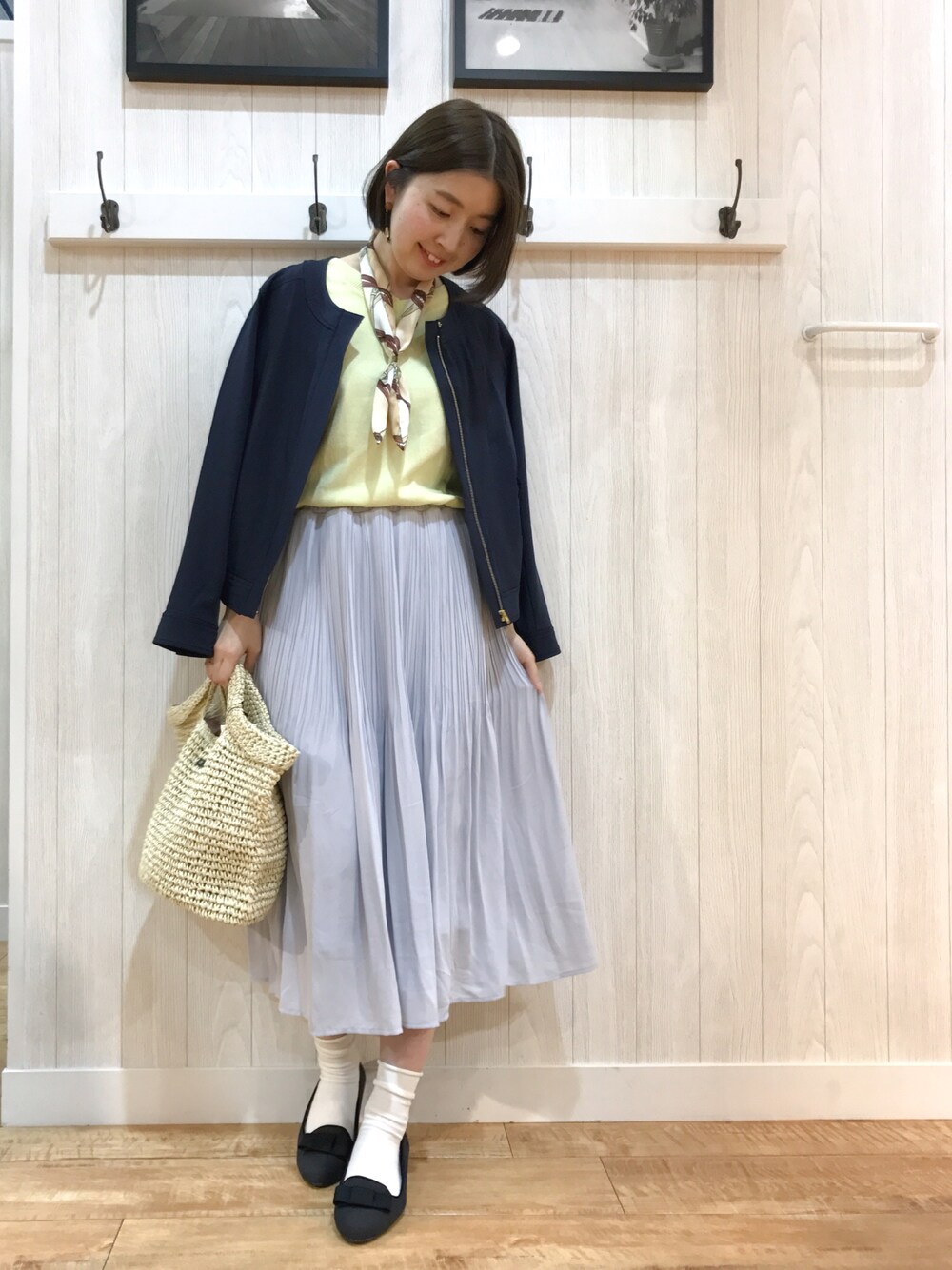 ブルー系のブルゾン、イエロー系のニット/セーター、ブルー系のスカートを着用したレディースの春コーディネートの1枚目の写真