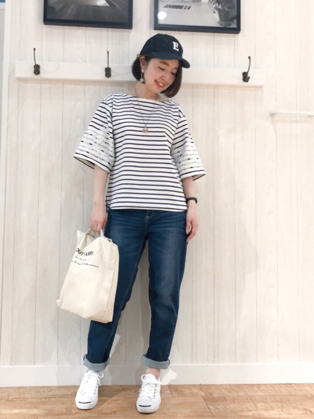 ブルー系のデニムパンツ、ホワイト系のTシャツ/カットソー、ホワイト系のショルダーバッグを着用したレディースの春コーディネートの1枚目の写真