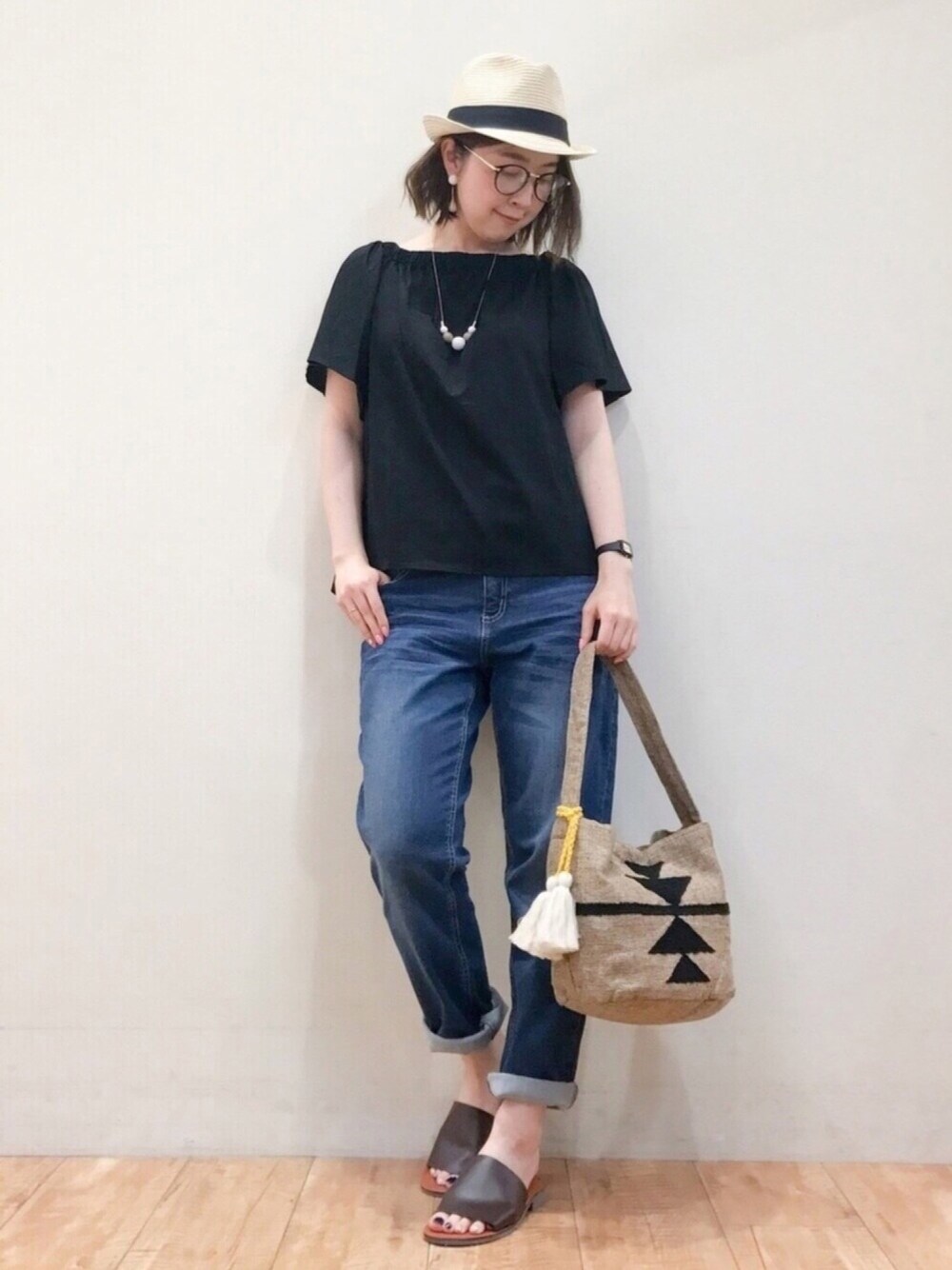 ブラック系のTシャツ/カットソー、ブルー系のデニムパンツ、ブラック系のショルダーバッグを着用したレディースの春コーディネートの1枚目の写真