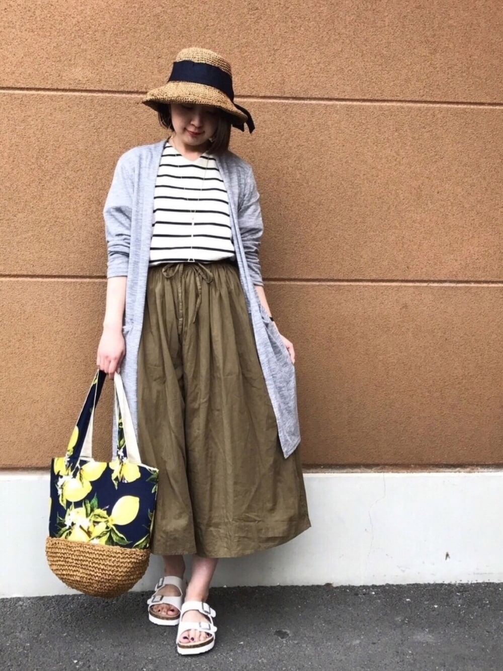 グレー系のカーディガン/ボレロ、ブラック系のTシャツ/カットソー、ブルー系のトートバッグを着用したレディースの春コーディネートの1枚目の写真