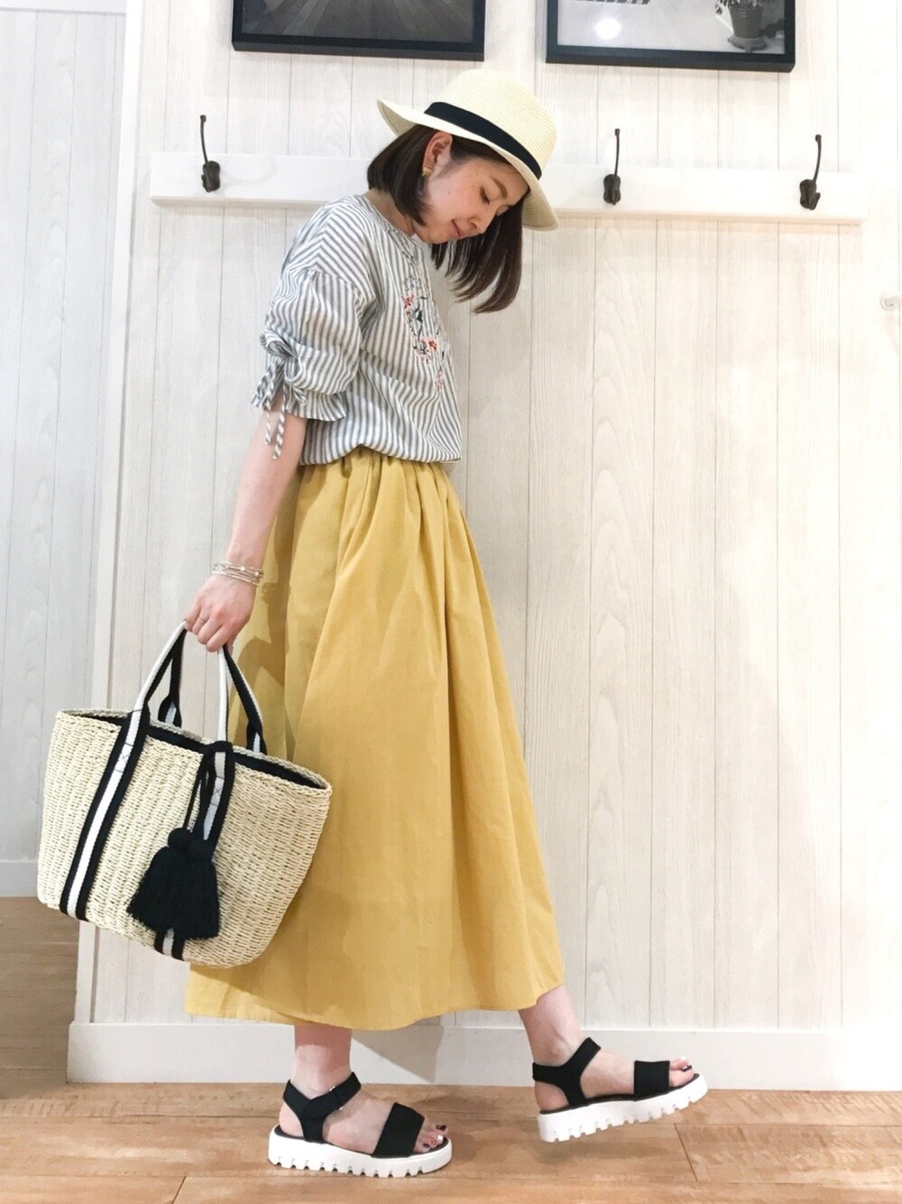 ブラック系のシャツ/ブラウス、イエロー系のスカート、ブラック系のトートバッグを着用したレディースの夏コーディネートの1枚目の写真