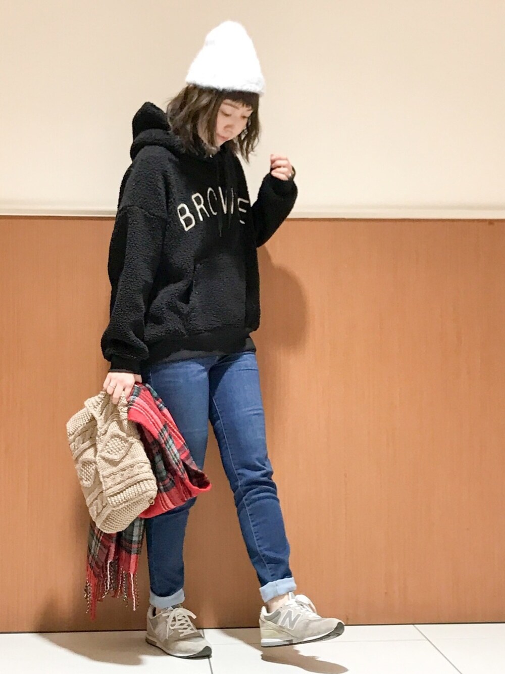 ブラック系のパーカー、ブルー系のデニムパンツ、ベージュ系のショルダーバッグを着用したレディースの秋コーディネートの1枚目の写真