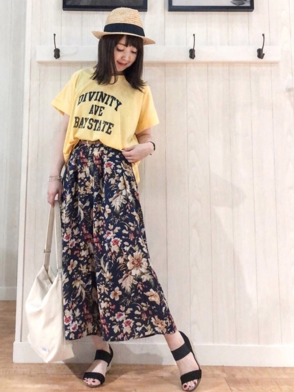 イエロー系のTシャツ/カットソー、ホワイト系のショルダーバッグ、ブラック系のサンダルを着用したレディースの夏コーディネートの1枚目の写真