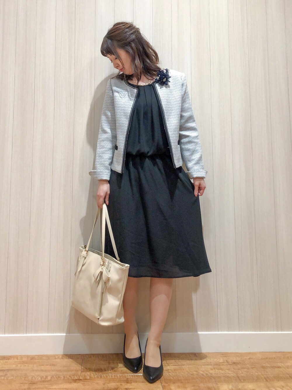 グレー系のセットアップ、ベージュ系のトートバッグ、ブラック系のパンプスを着用したレディースの冬コーディネートの1枚目の写真