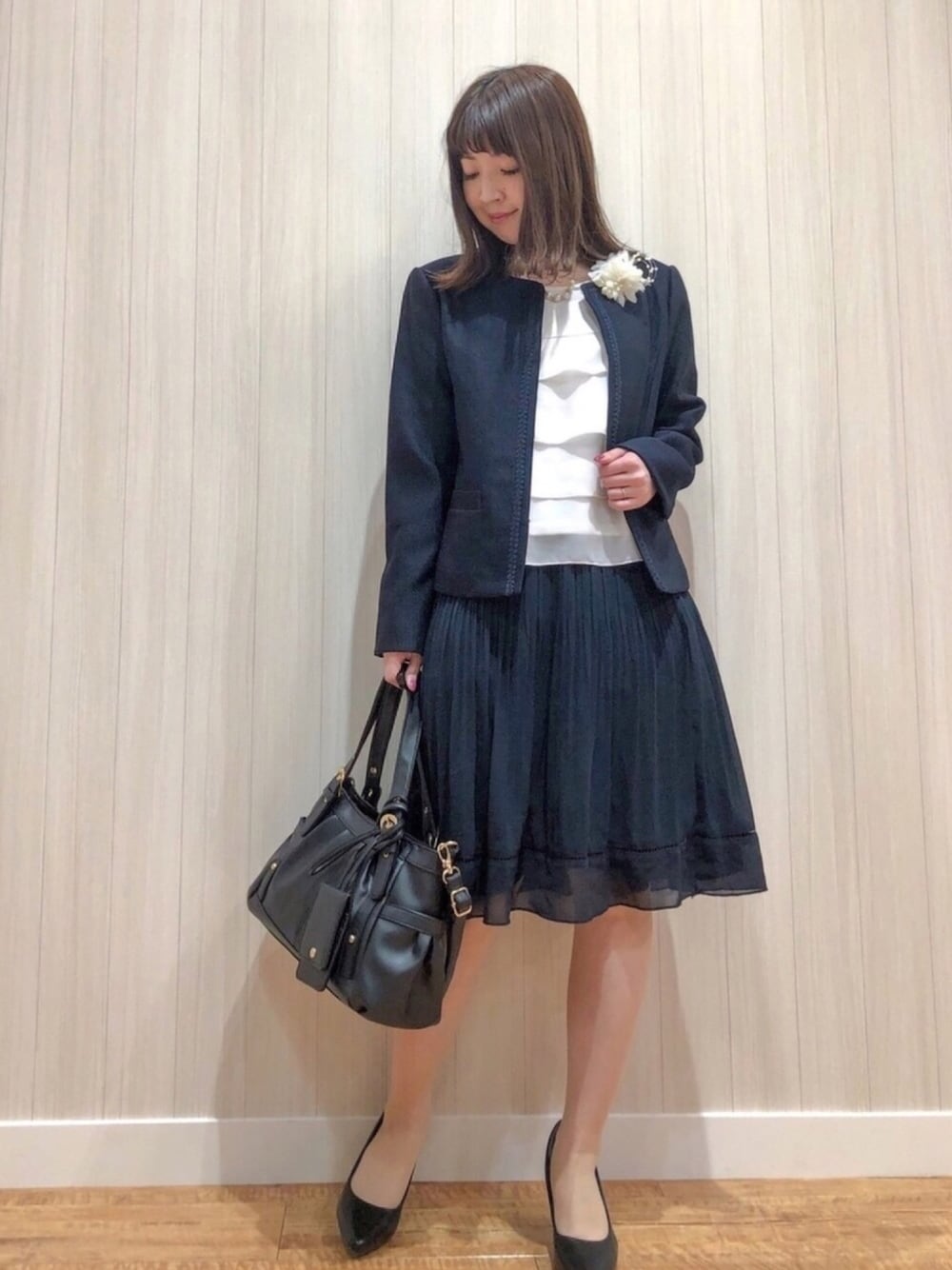 ブルー系のノーカラージャケット、ホワイト系のシャツ/ブラウス、ブルー系のスカートを着用したレディースの冬コーディネートの1枚目の写真