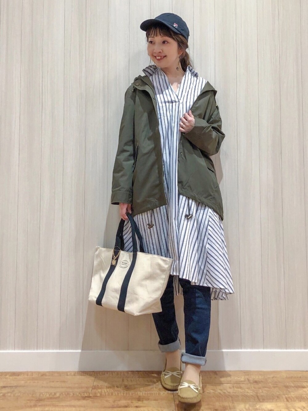 グリーン系のその他アウター、ベージュ系のワンピース、ブルー系のその他パンツを着用したレディースの春コーディネートの1枚目の写真