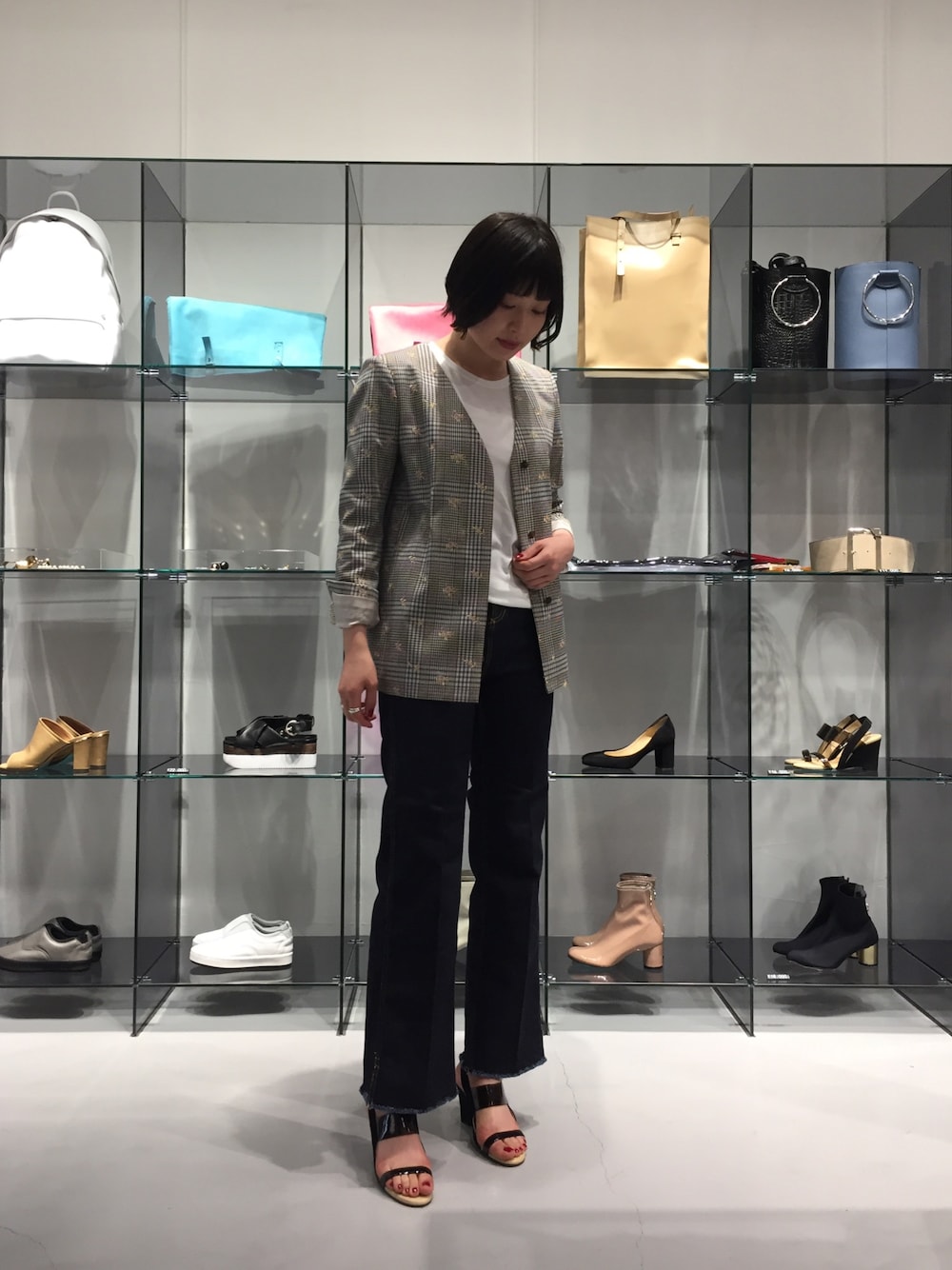 ピンク系のノーカラージャケット、ブルー系のデニムパンツ、ブラック系のサンダルを着用したレディースの春コーディネートの1枚目の写真