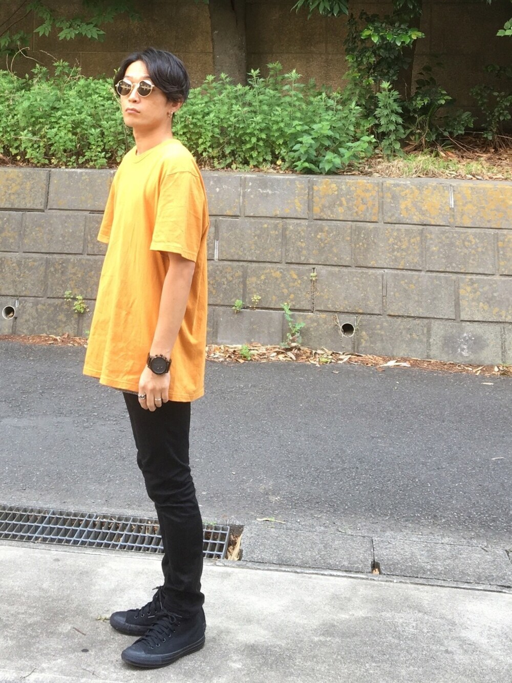 ブラック系のスニーカー、ブラック系のデニムパンツ、イエロー系のTシャツ/カットソーを着用したメンズの夏コーディネートの1枚目の写真