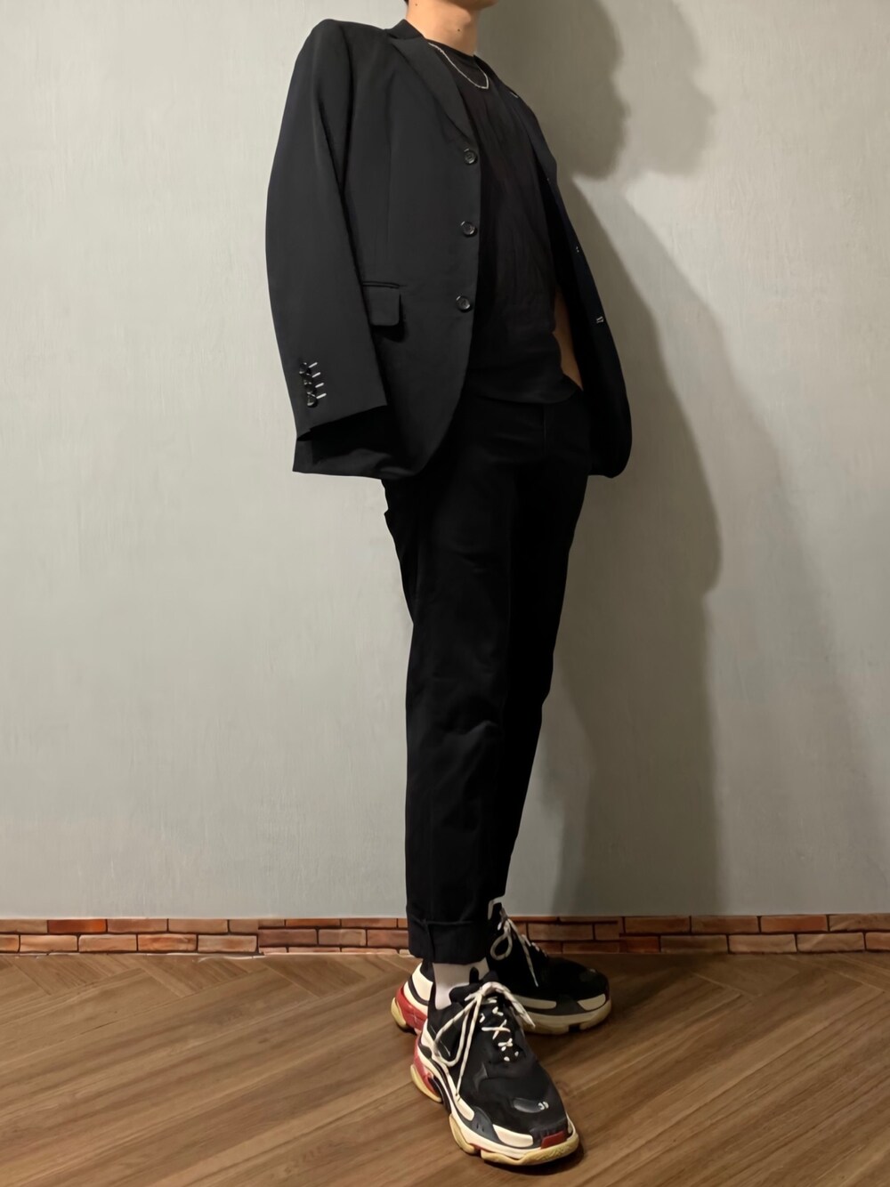 ブラック系のテーラードジャケット、ブラック系のチノパンツ、ブラック系のTシャツ/カットソーを着用したメンズの秋コーディネートの1枚目の写真