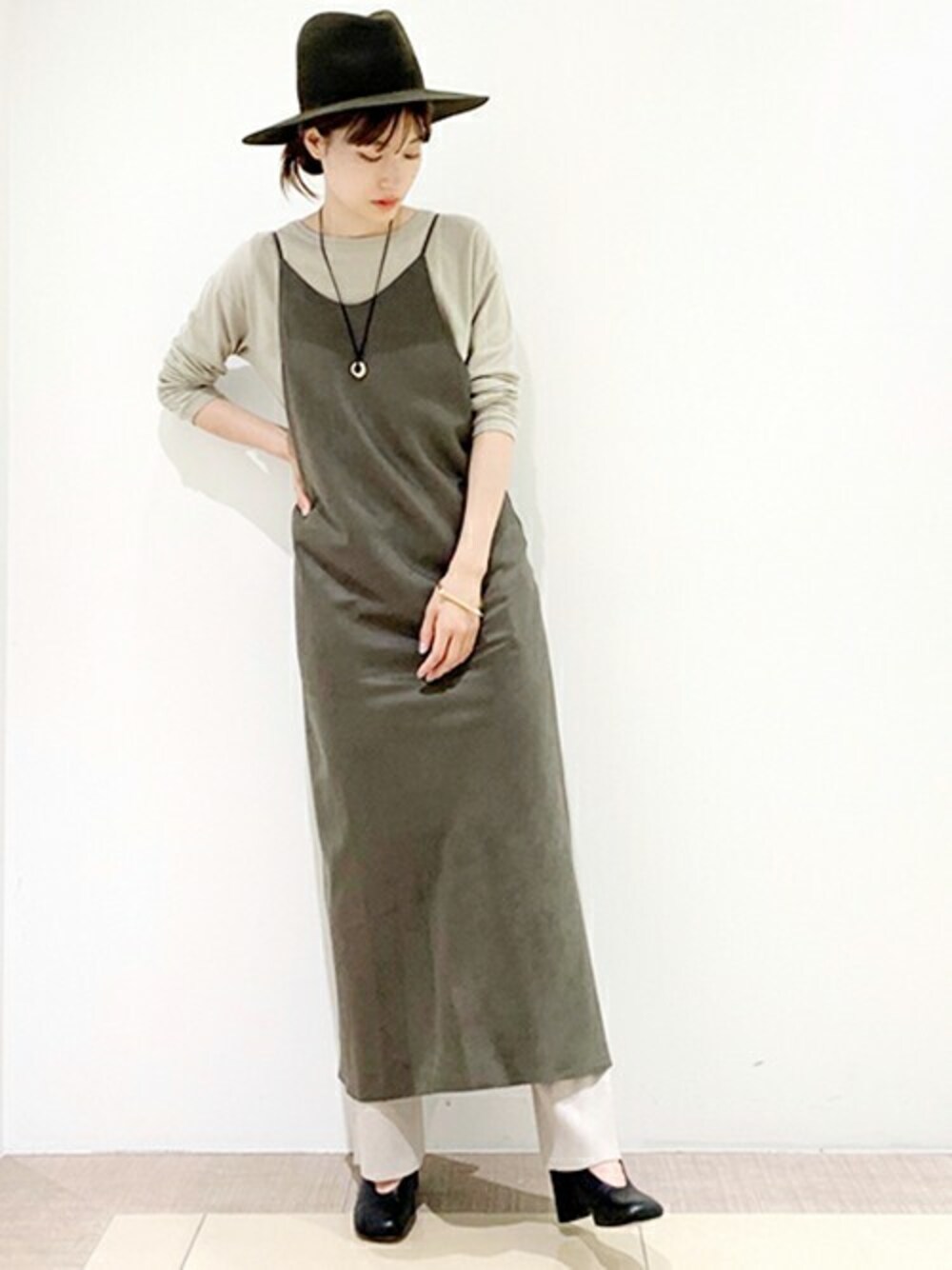 グリーン系のワンピース、ベージュ系のTシャツ/カットソー、ベージュ系のその他パンツを着用したレディースの秋コーディネートの1枚目の写真