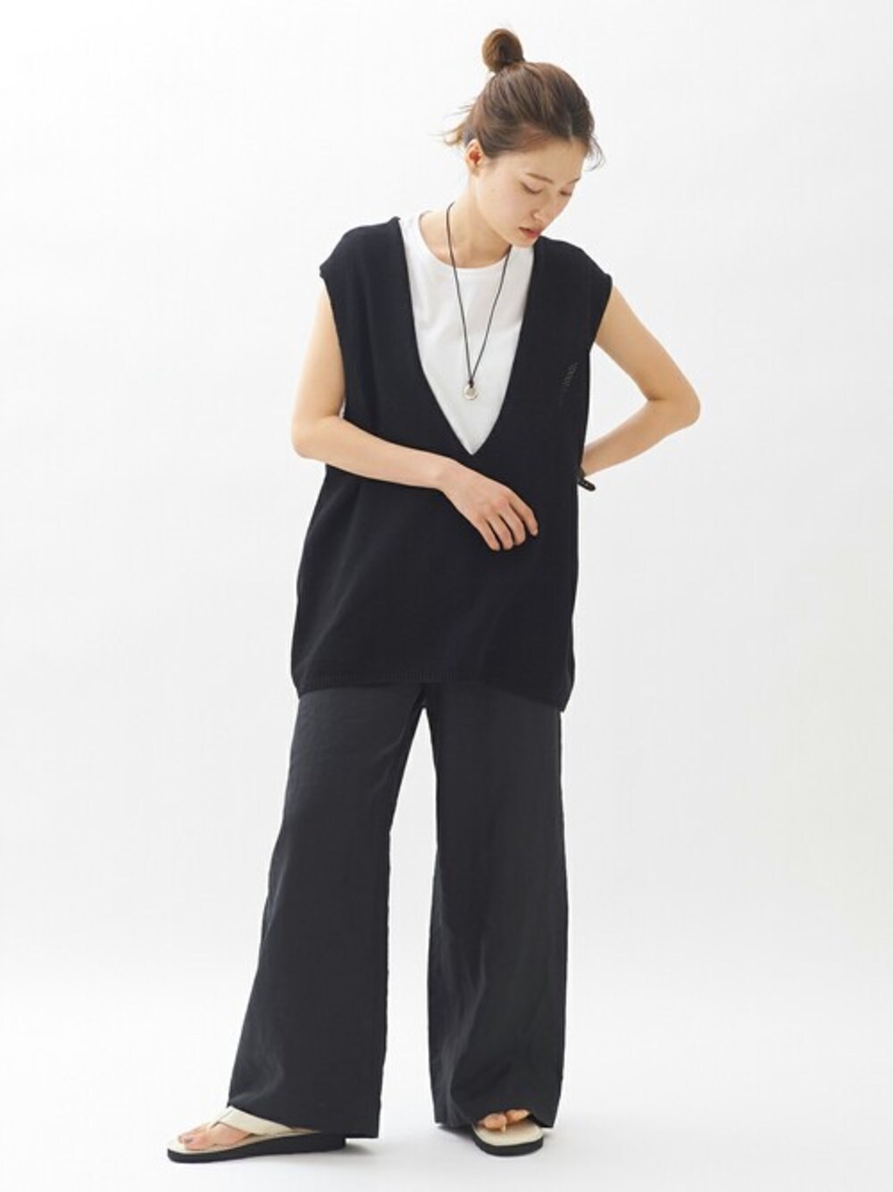 ブラック系のその他パンツ、ブラック系のベスト、ホワイト系のTシャツ/カットソーを着用したレディースの春コーディネートの1枚目の写真