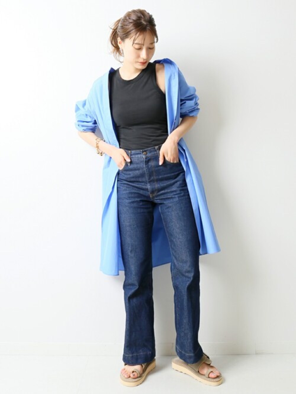 ブルー系のシャツ/ブラウス、ブラック系のタンクトップ、ブルー系のデニムパンツを着用したレディースの春コーディネートの1枚目の写真
