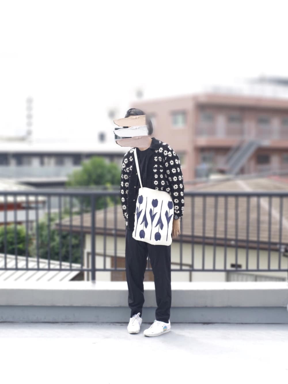 ブラック系のカーディガン/ボレロ、ブラック系のスラックス、ホワイト系のスニーカーを着用したメンズの秋コーディネートの1枚目の写真
