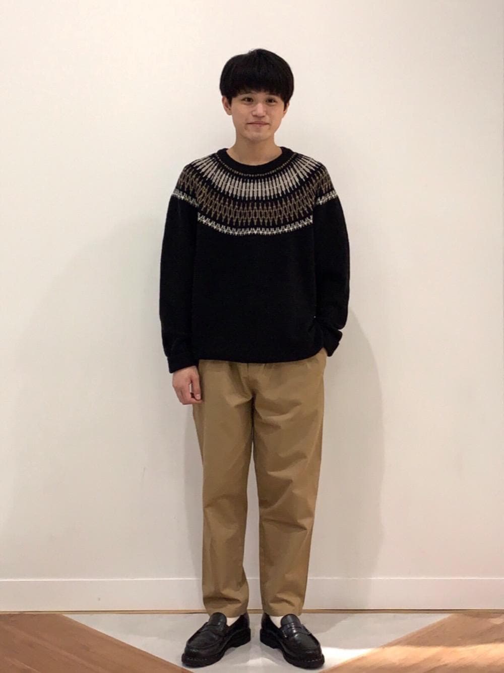 ベージュ系のその他パンツ、ベージュ系のダウンジャケット/コート、ブラック系のニット/セーターを着用したメンズの冬コーディネートの1枚目の写真