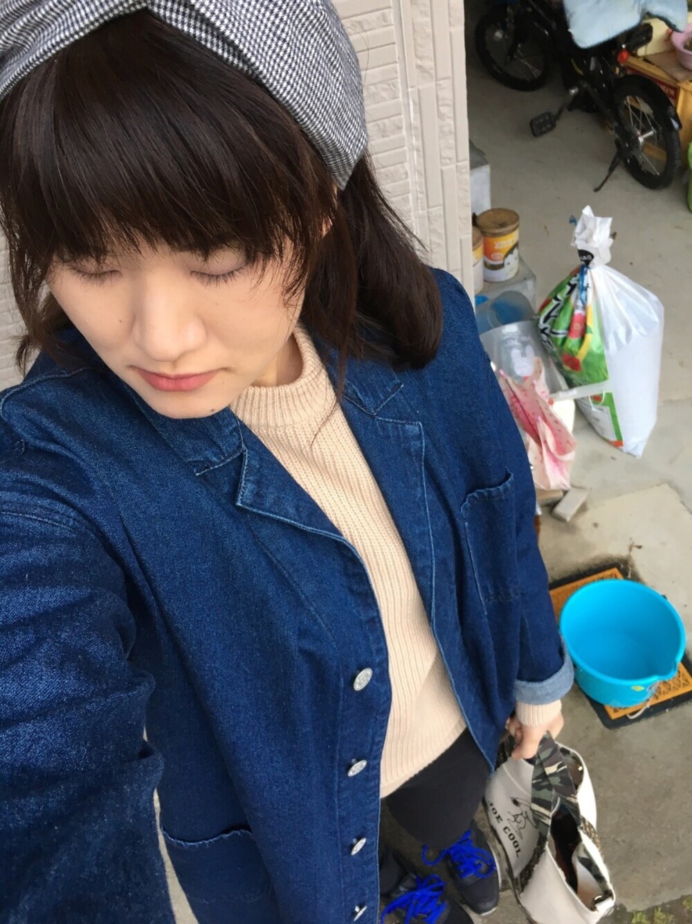 ブルー系のデニムジャケット、ブラック系のデニムパンツ、ホワイト系のトートバッグを着用したレディースの春コーディネートの1枚目の写真