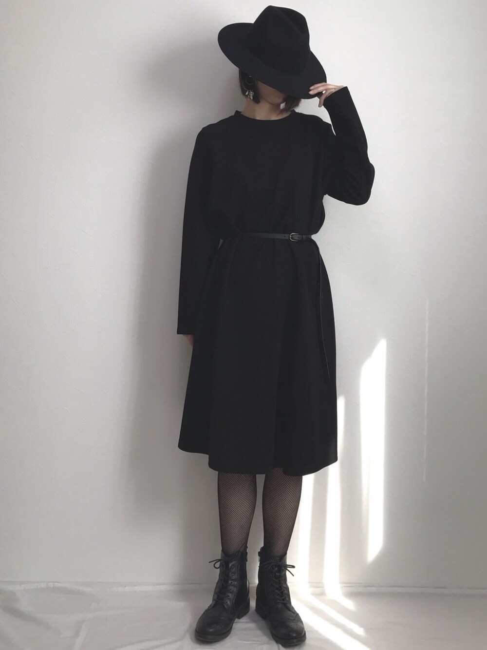 ブラック系のワンピース、ブラック系のブーツ、ブラック系のハットを着用したレディースの秋コーディネートの1枚目の写真