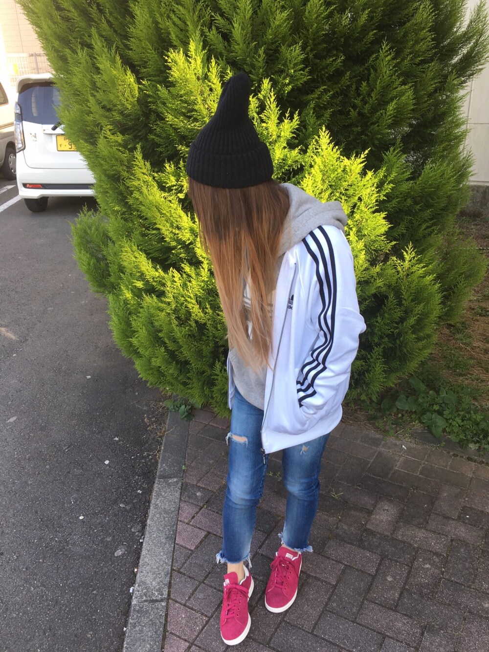 ホワイト系のジャージ、グレー系のパーカー、ブルー系のデニムパンツを着用したレディースの冬コーディネートの1枚目の写真