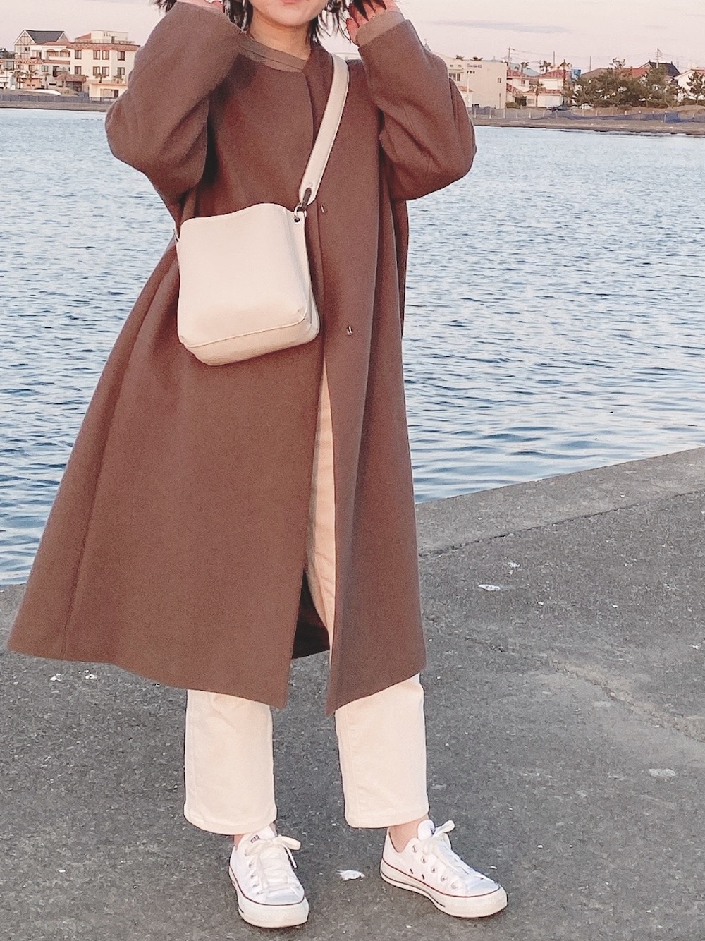 ブラウン系のTシャツ/カットソー、ブラウン系のその他アウター、ホワイト系のショルダーバッグを着用したレディースの冬コーディネートの1枚目の写真