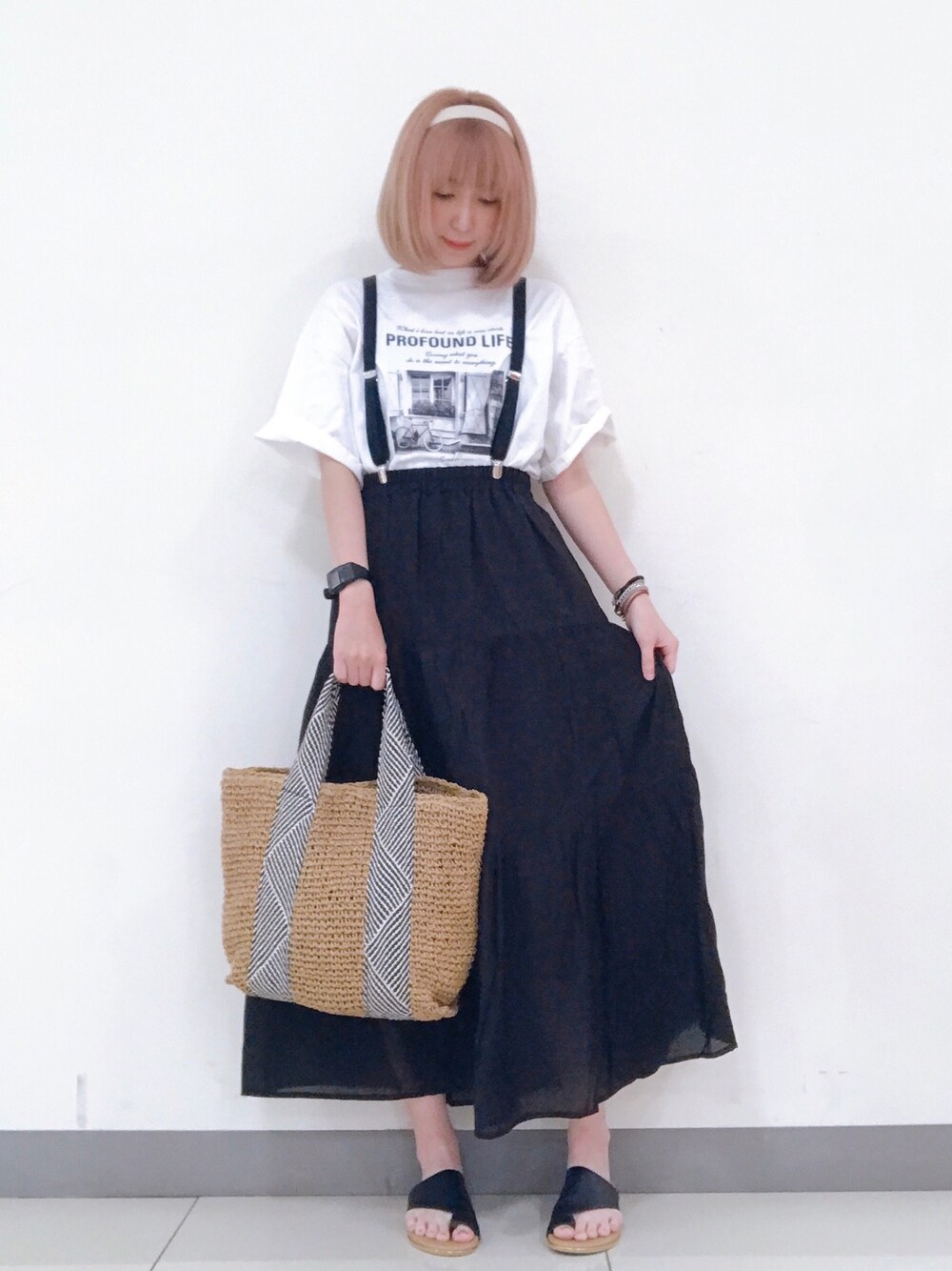 ホワイト系のTシャツ/カットソー、ブラック系のスカート、ブラック系のサンダルを着用したレディースの夏コーディネートの1枚目の写真