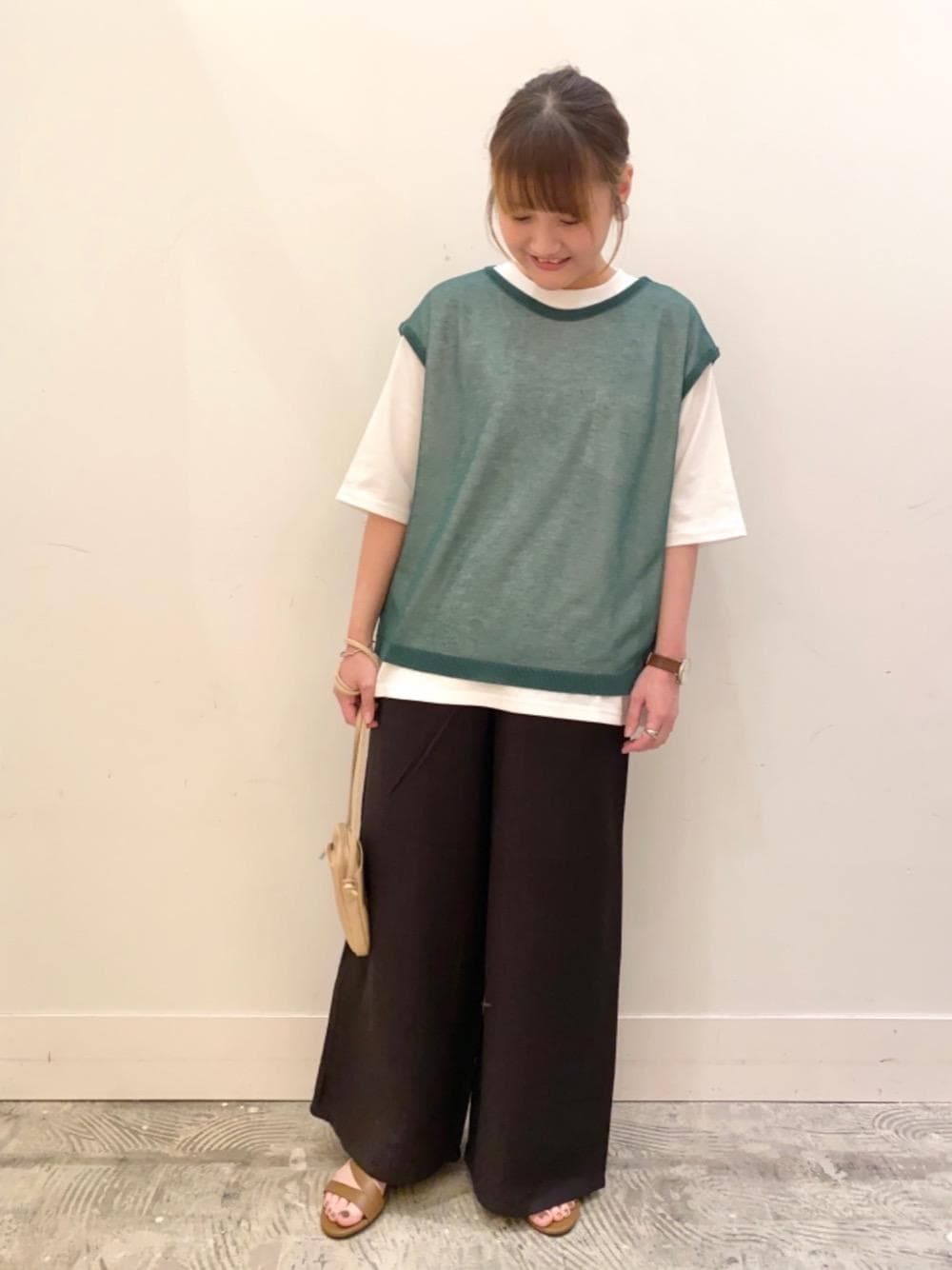 ベージュ系のショルダーバッグ、ブラウン系のサンダル、ホワイト系のTシャツ/カットソーを着用したレディースの夏コーディネートの1枚目の写真