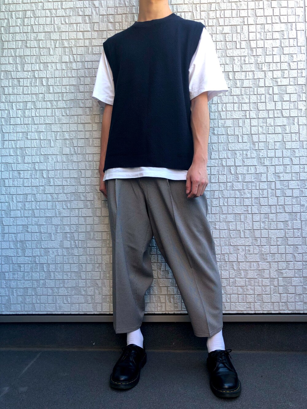 ブルー系のベスト、ベージュ系のスラックス、ホワイト系のTシャツ/カットソーを着用したメンズの夏コーディネートの1枚目の写真