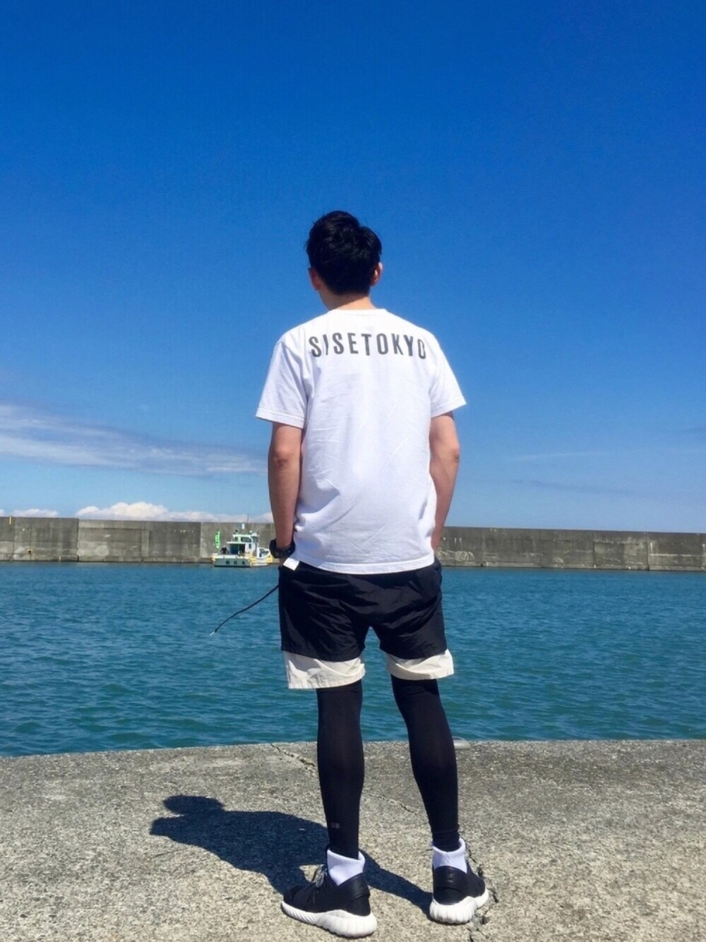 「夏コーデ、モノトーン、シンプル、Tシャツ、白Tシャツ、バックプリント、ショートパンツ、レギンス、スニーカー、adidas originals」｜「SISEのアイテム（Tシャツ/カットソー、ホワイト系）」を使った、Heroさん（メンズ・173cm）の春コーディネートの1枚目の写真