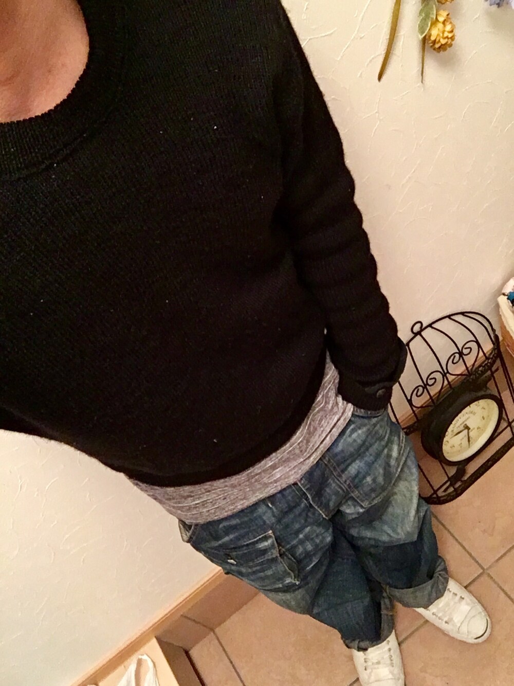 ブラック系のニット/セーター、グレー系のタンクトップ、ブルー系のデニムパンツを着用したメンズの春コーディネートの1枚目の写真