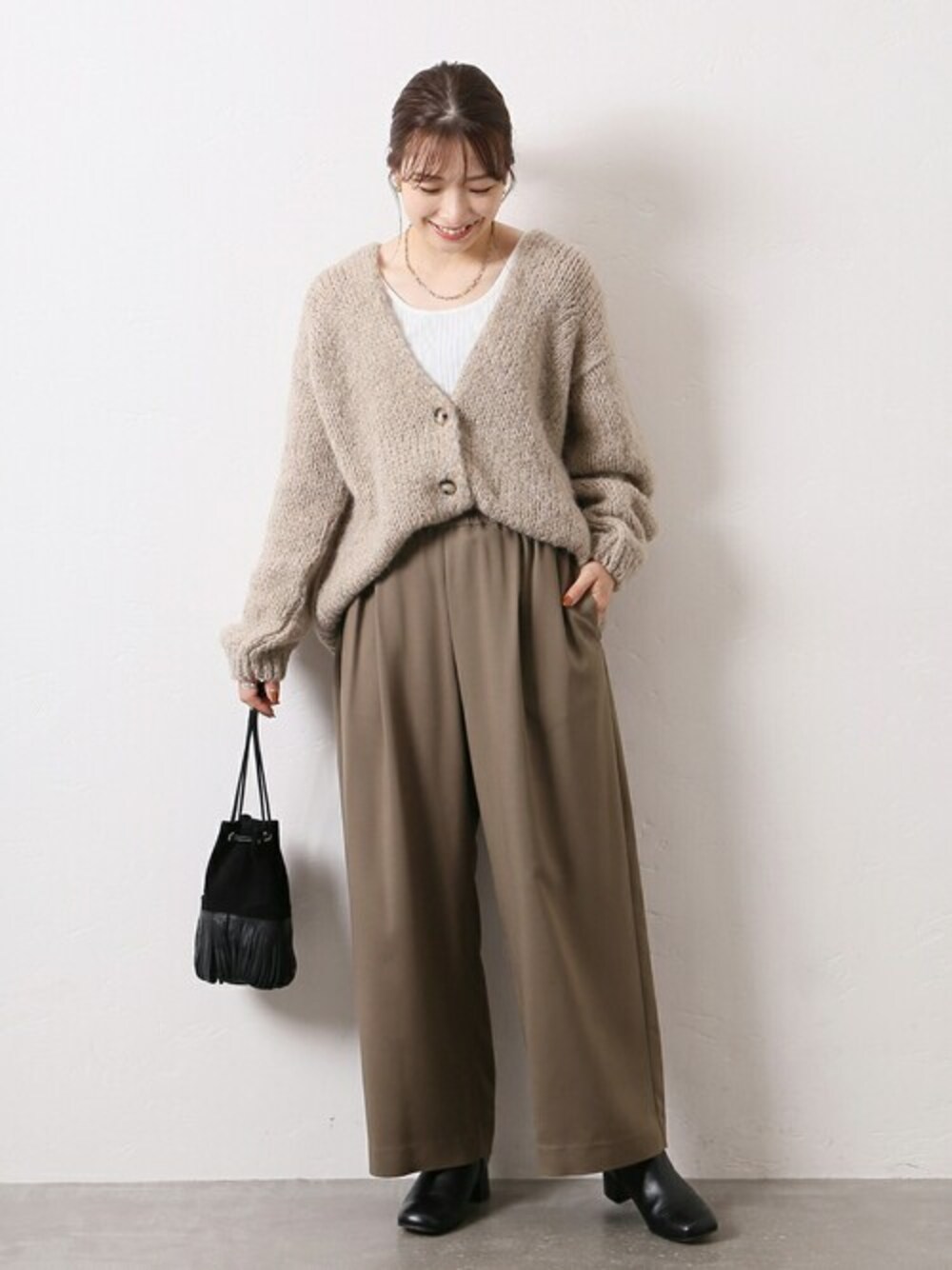 ブラウン系のその他パンツ、ベージュ系のカーディガン/ボレロ、ホワイト系のタンクトップを着用したレディースの秋コーディネートの1枚目の写真