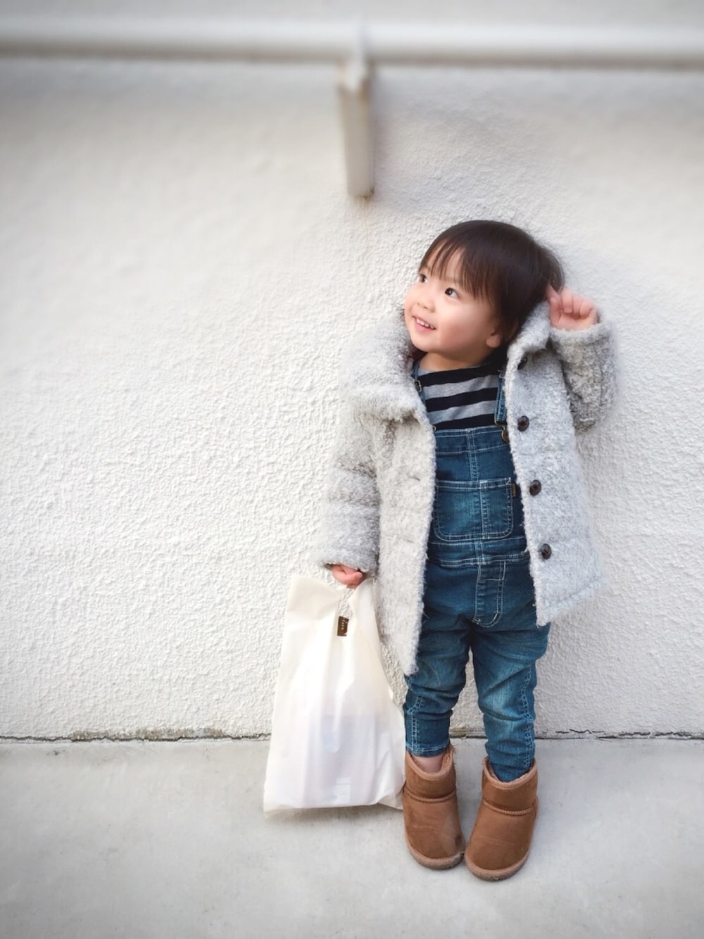 グレー系のダウンジャケット/コート、ブルー系のTシャツ/カットソー、ブルー系のサロペット/オーバーオールを着用したキッズの冬コーディネートの1枚目の写真