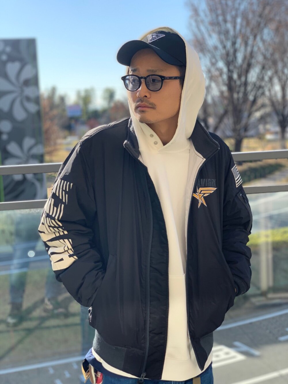 ホワイト系のパーカー、ブラック系のMA-1、ブラック系のキャップを着用したメンズの冬コーディネートの1枚目の写真