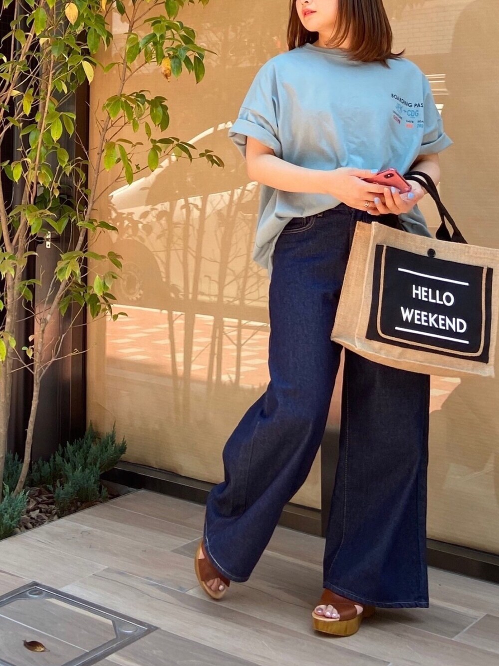 ブルー系のTシャツ/カットソー、ブラック系のかごバッグ、ブルー系のデニムパンツを着用したレディースの夏コーディネートの1枚目の写真