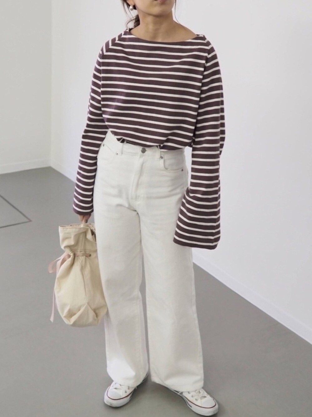 ブラウン系のTシャツ/カットソー、ホワイト系のその他パンツ、ホワイト系のハンドバッグを着用したレディースの春コーディネートの1枚目の写真