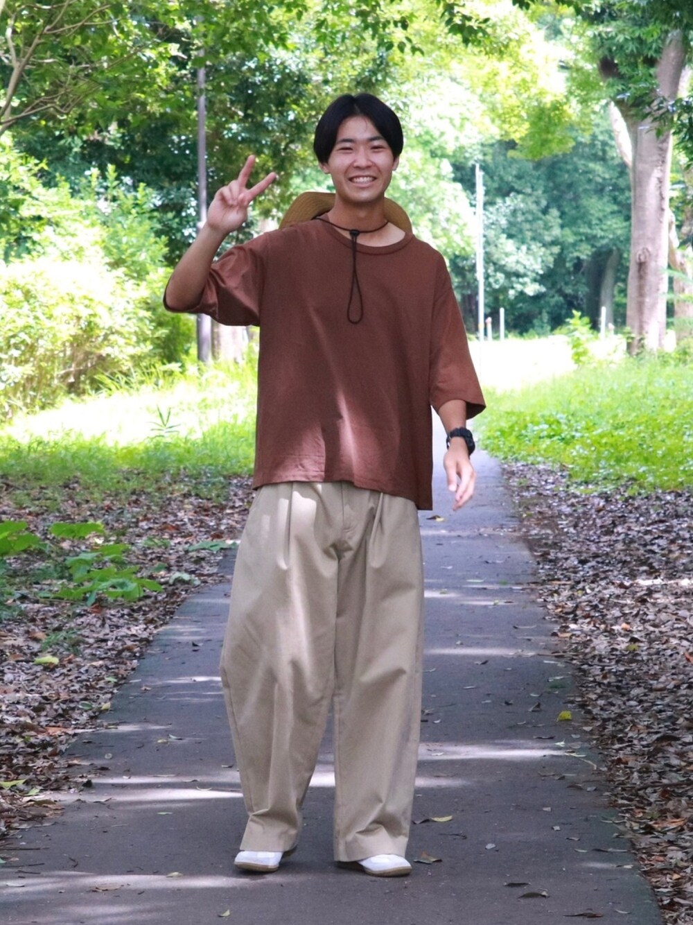 ブラウン系のTシャツ/カットソー、ベージュ系のその他パンツ、ホワイト系のスニーカーを着用したメンズの秋コーディネートの1枚目の写真