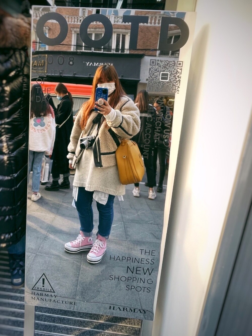 ピンク系のスニーカー、ブルー系のデニムパンツ、イエロー系のバッグを着用したレディースの冬コーディネートの1枚目の写真