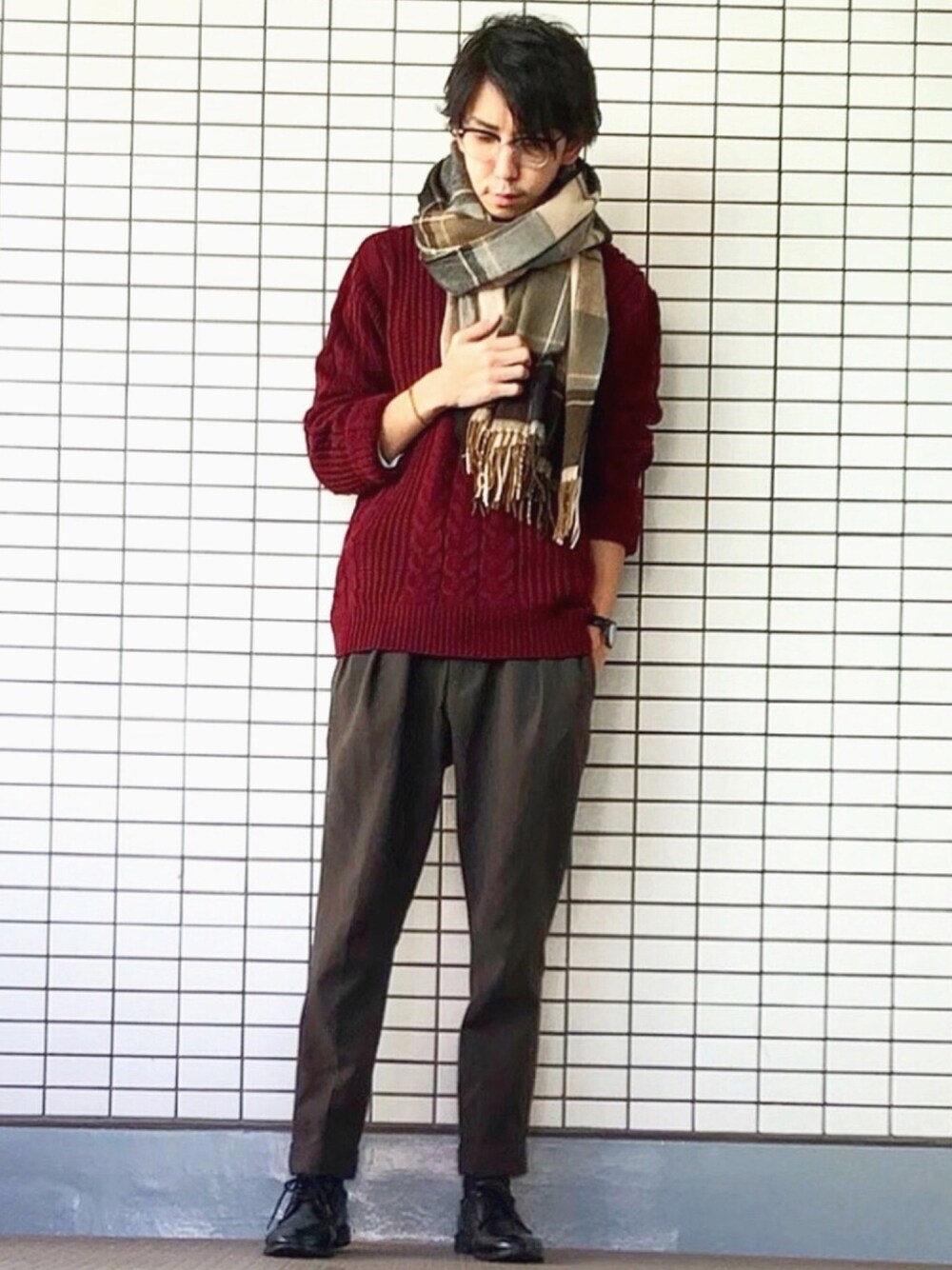 レッド系のニット/セーター、グリーン系のその他パンツ、ベージュ系のストール/ショールを着用したメンズの冬コーディネートの1枚目の写真