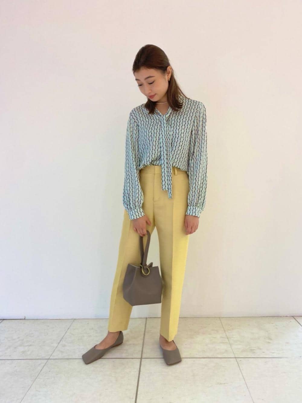 イエロー系のその他パンツ、グレー系のパンプス、グレー系のハンドバッグを着用したレディースの秋コーディネートの1枚目の写真