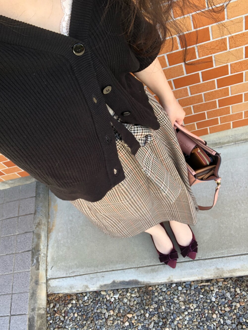 ブラウン系のスカート、ピンク系のトートバッグ、レッド系のパンプスを着用したレディースの秋コーディネートの1枚目の写真