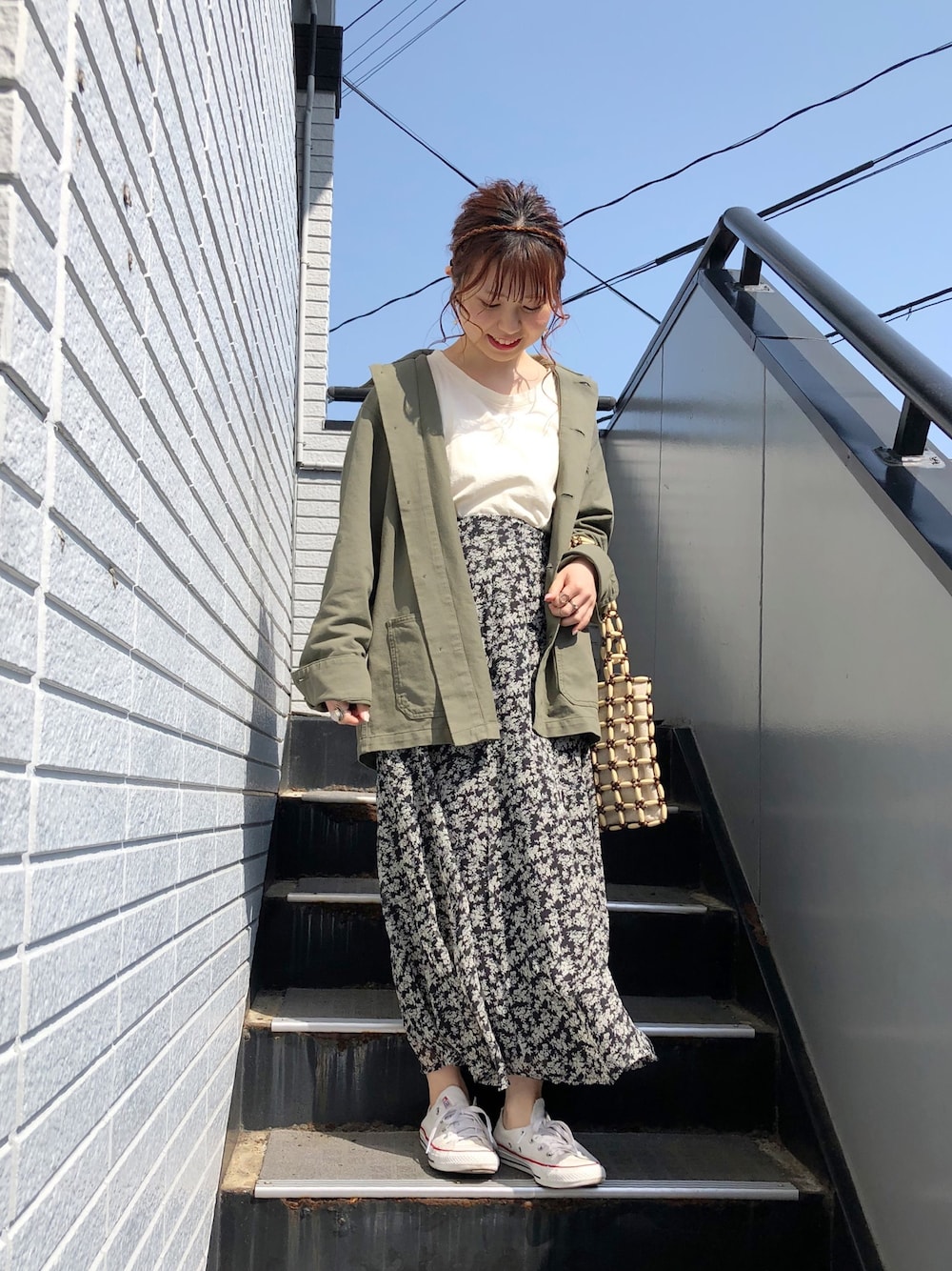 ホワイト系のTシャツ/カットソー、ブラック系のスカート、ベージュ系のトートバッグを着用したレディースの春コーディネートの1枚目の写真