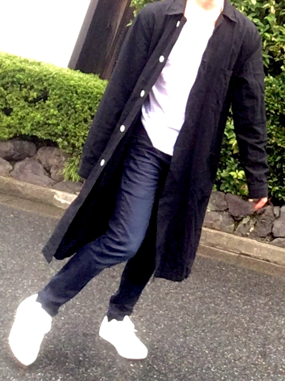 ブラック系のチェスターコート、ホワイト系のTシャツ/カットソー、ブラック系のデニムパンツを着用したメンズの秋コーディネートの1枚目の写真