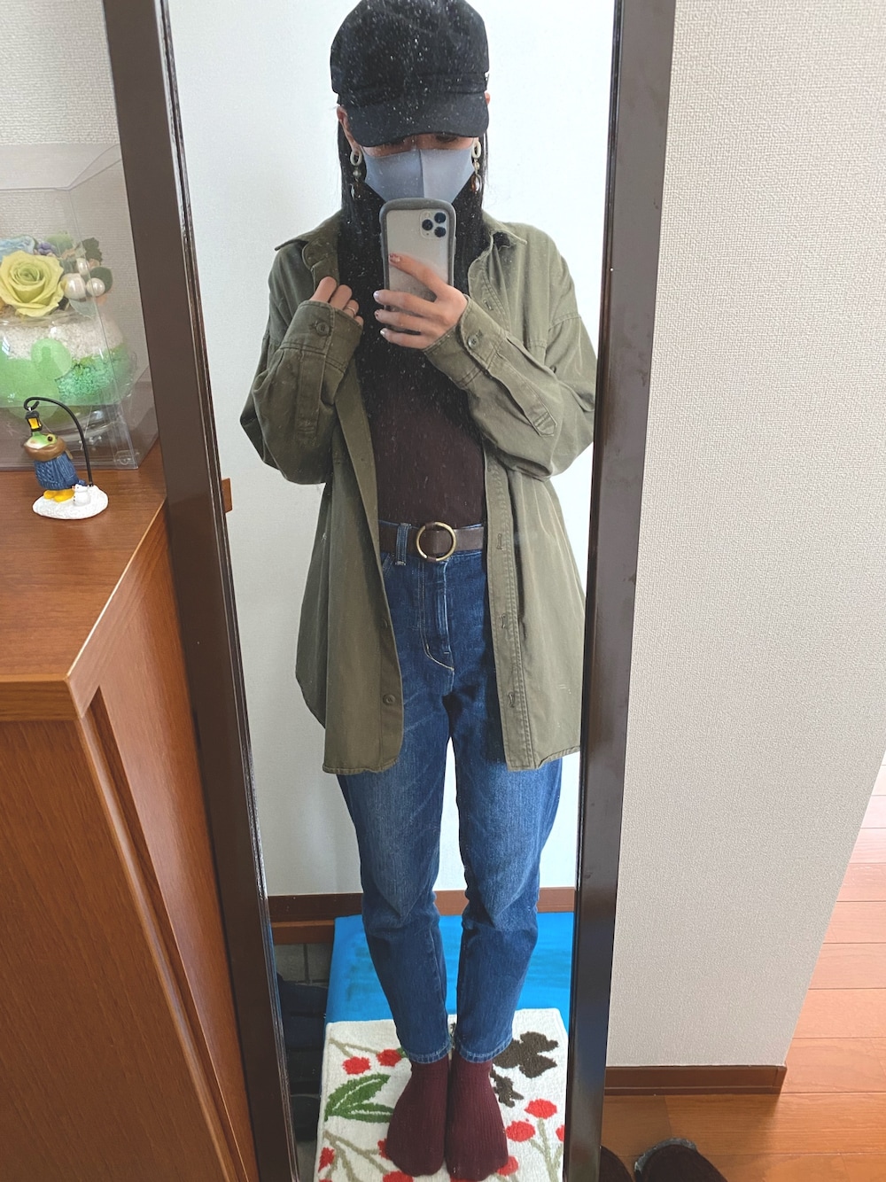 グリーン系のシャツ/ブラウス、ブラウン系のTシャツ/カットソー、ブルー系のデニムパンツを着用したレディースの春コーディネートの1枚目の写真