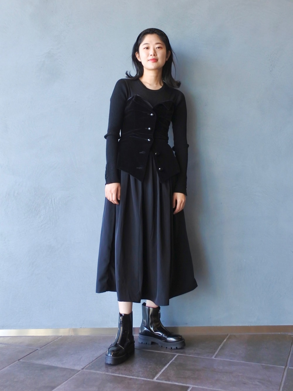 ブラック系のワンピース、ブラック系のベスト、ブラック系のシューズを着用したレディースの冬コーディネートの1枚目の写真