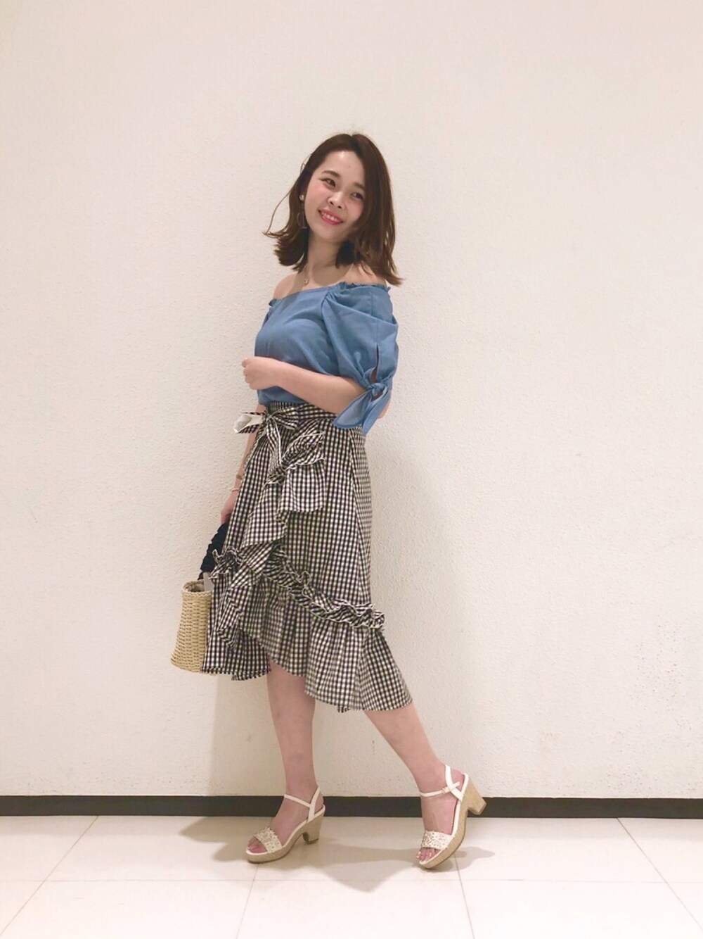 「ウィルセレクション、willselection、ウィルガール、オフショル、オフショルブラウス、ダンガリーシャツ、ギンガムチェック、ギンガムチェックスカート、フリルスカート、かごバッグ」｜「WILLSELECTIONの【雑誌掲載】3Dフラワーサンダル（サンダル、ホワイト系）」を使った、yuka.c5さん（レディース・159cm）の春コーディネートの1枚目の写真