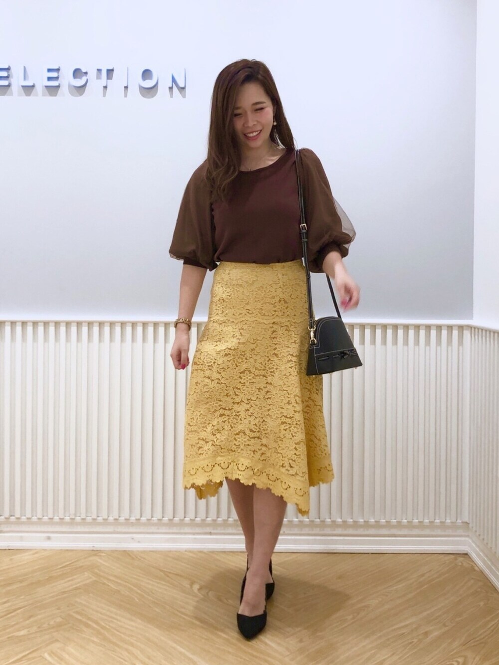 ブラック系のショルダーバッグ、ブラウン系のニット/セーターを着用したレディースの秋コーディネートの1枚目の写真